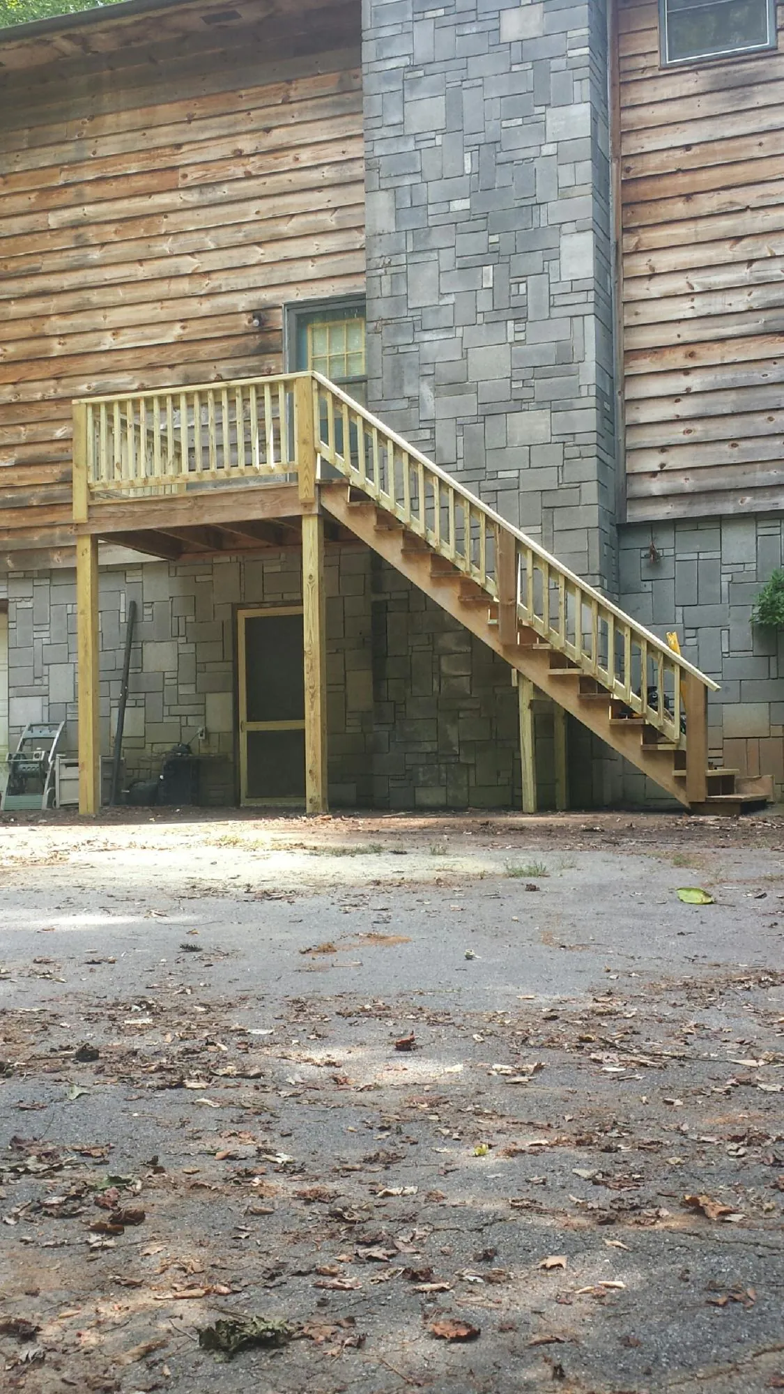 New pressure treated deck and stair landing on a log home in Crete